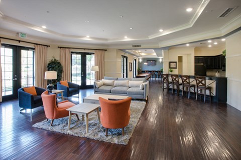 A living room with a grey couch and orange chairs.