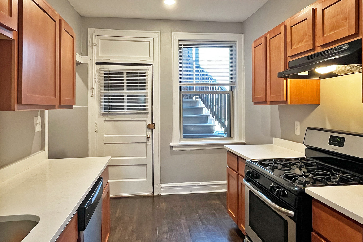 A kitchen with wooden cabinets and a black stove top oven.