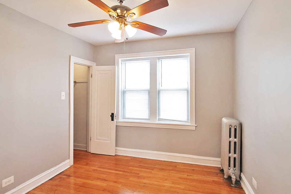an empty room with a ceiling fan and a window
