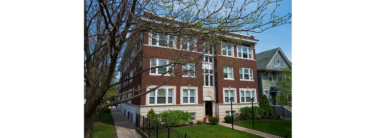 a large brick building with a tree in front of it