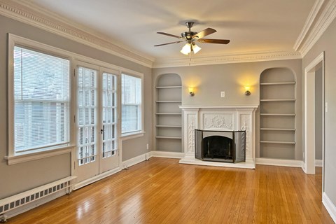 A room with a fireplace and a ceiling fan.
