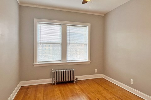 A room with a window and a radiator on the floor.