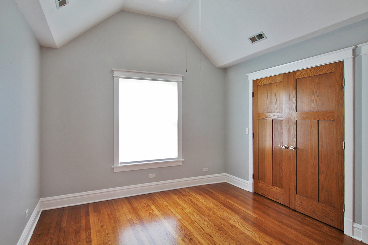 an empty room with a wooden door and a window