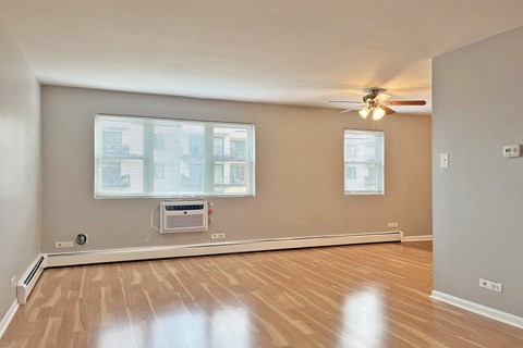 A room with a window and a fan on the ceiling.