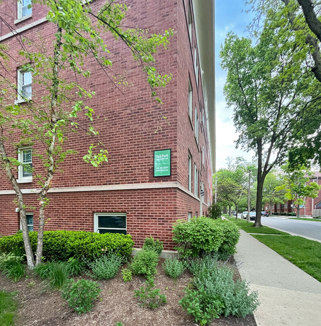 A red brick building with a green sign on it.
