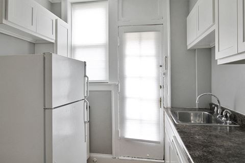 a kitchen with a refrigerator freezer next to a window