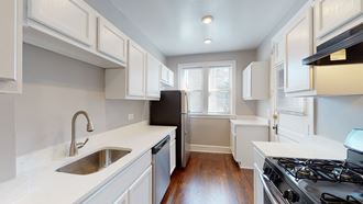a kitchen with white cabinets and white countertops