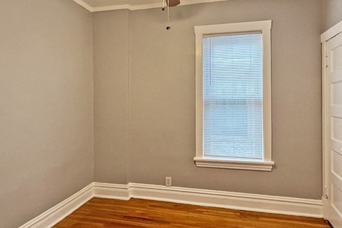 A room with a window and wooden floors.