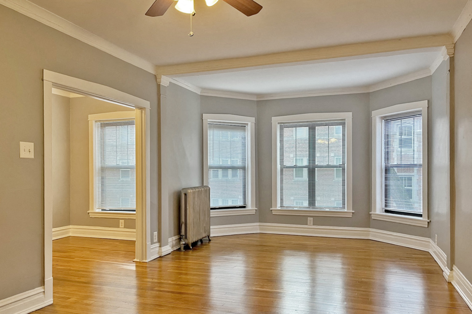 A room with a wood floor and a ceiling fan.
