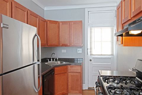 a kitchen with wooden cabinets and a stainless steel refrigerator