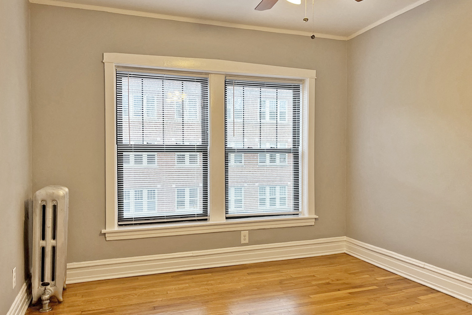 A room with a window and a radiator on the floor.