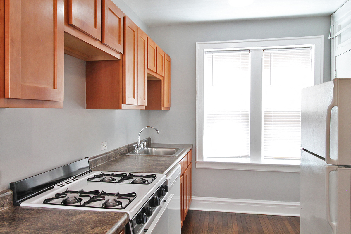 a kitchen with a stove and a sink and a window