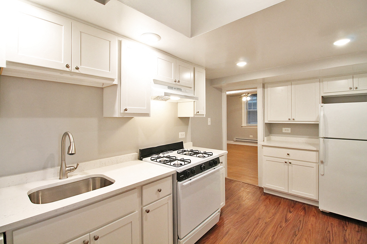 a kitchen with white cabinets and a stove and a sink