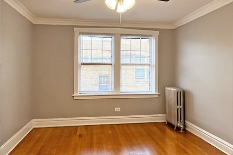 A room with a window and a radiator on the floor.