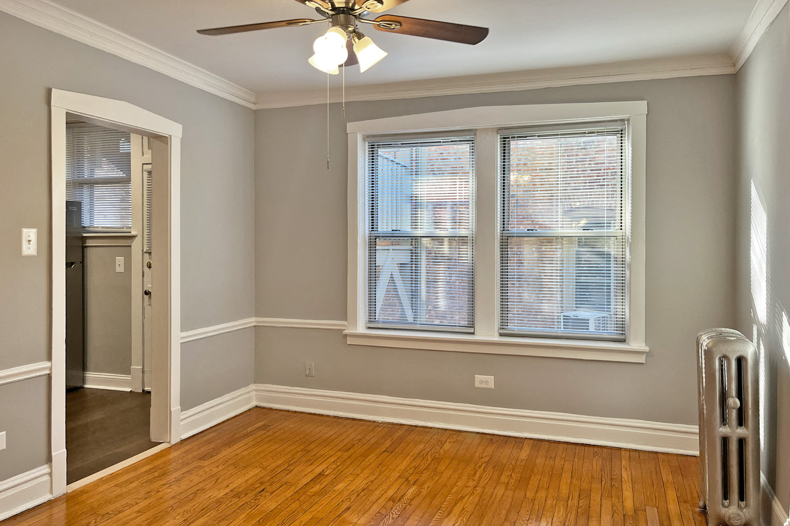 A room with a ceiling fan and a window.