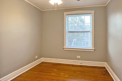 A room with a window and wooden flooring.