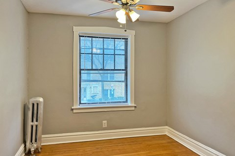 A room with a window and a fan.
