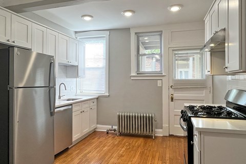 A kitchen with a stainless steel refrigerator and a black stove top oven.