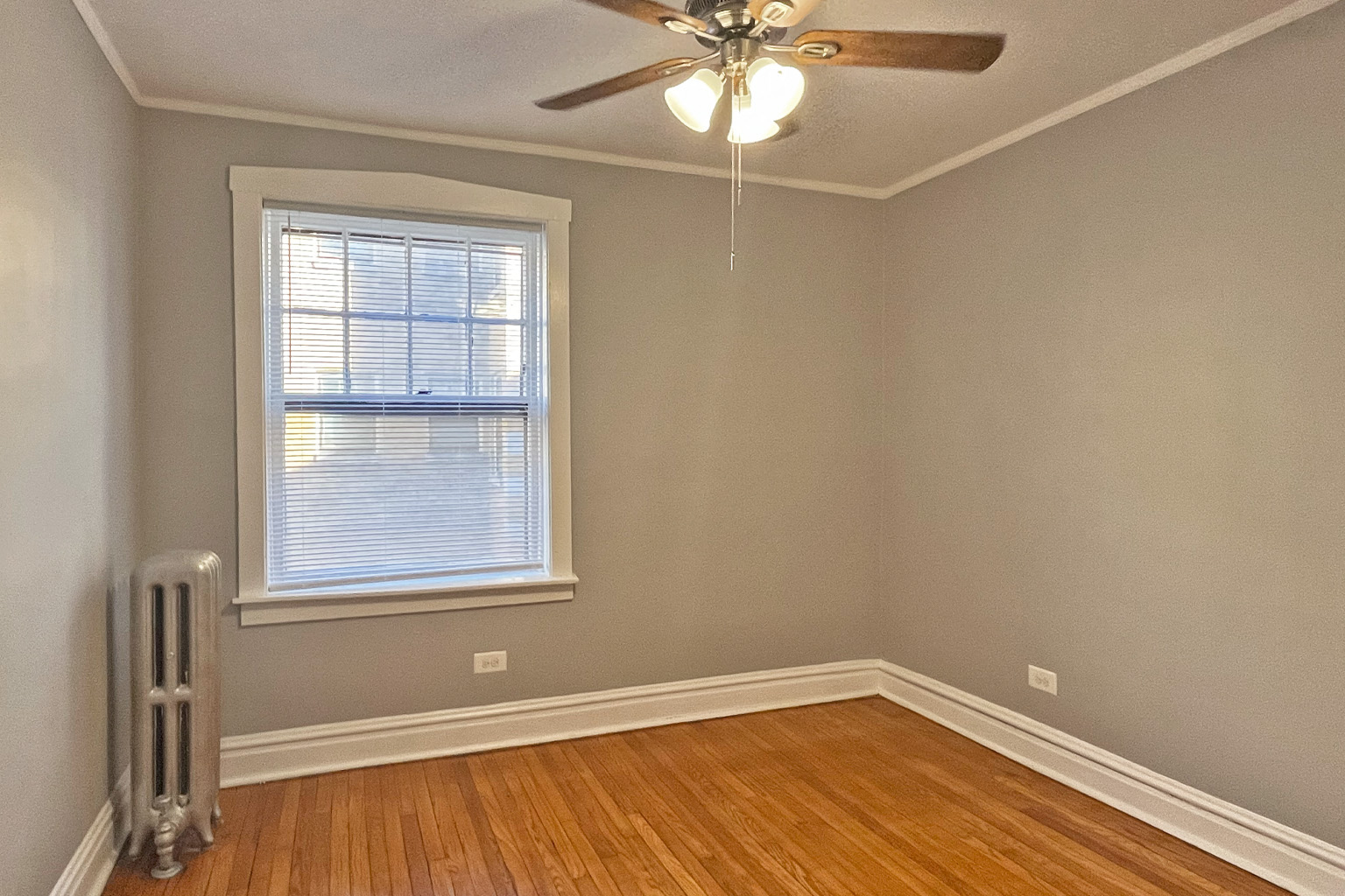A room with a window and a ceiling fan.