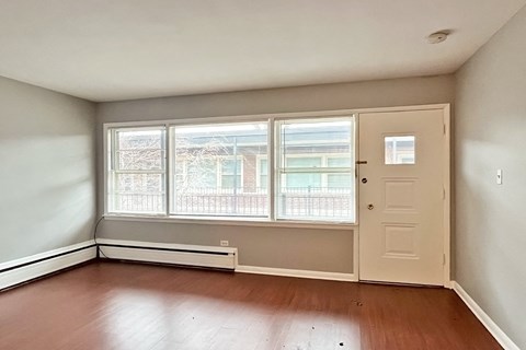A room with a door, window, and radiator.