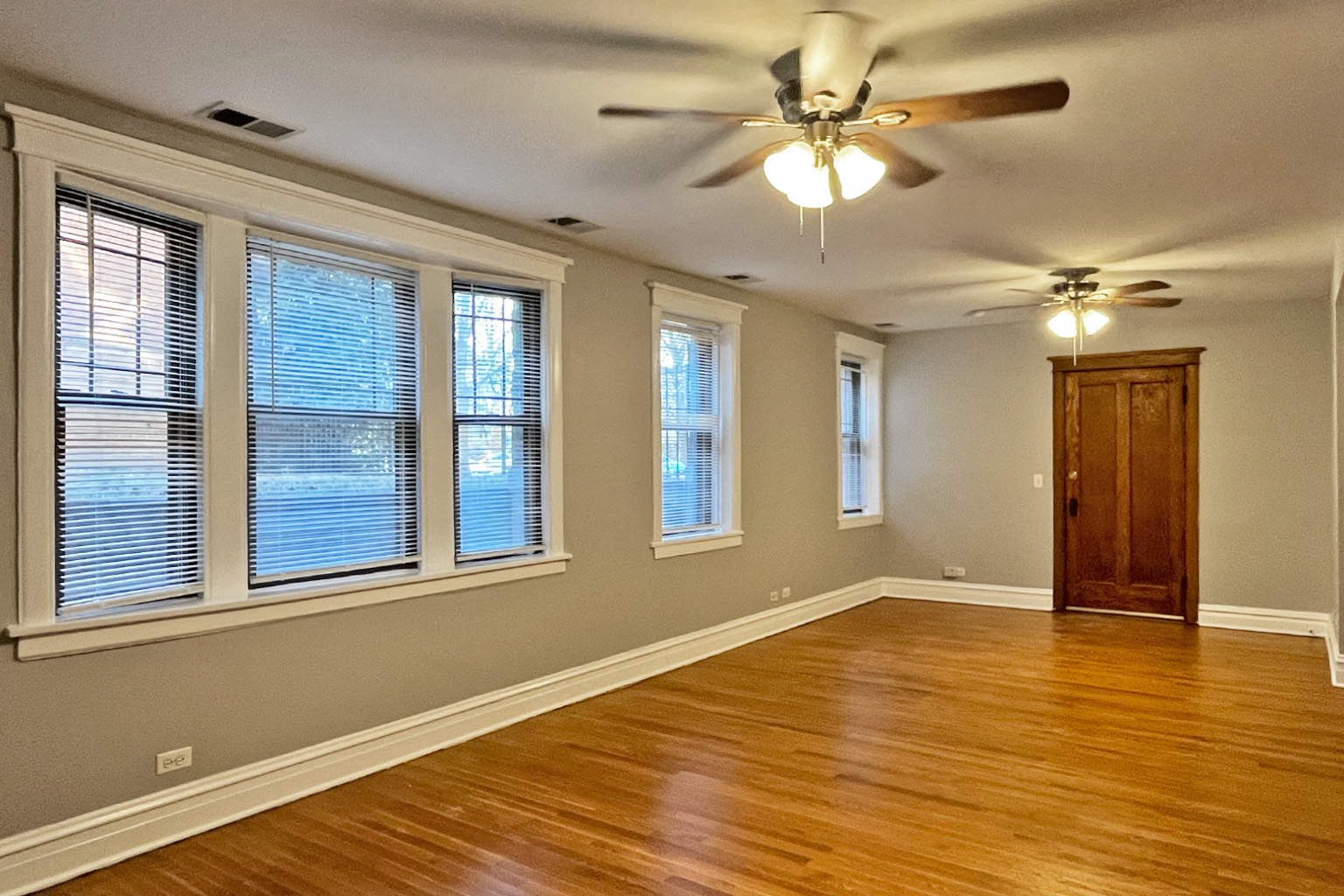 A room with wooden floors and a ceiling fan.