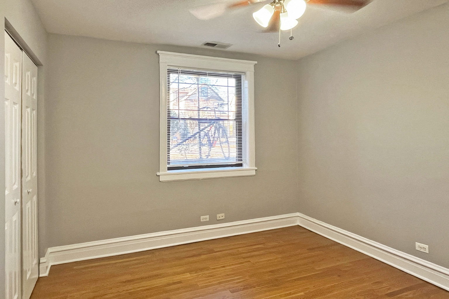 A room with a window and a ceiling fan.
