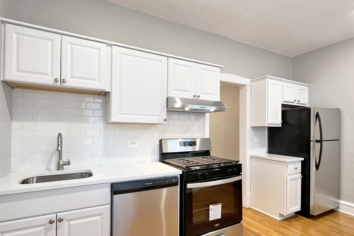 A kitchen with white cabinets and a black stove top oven.
