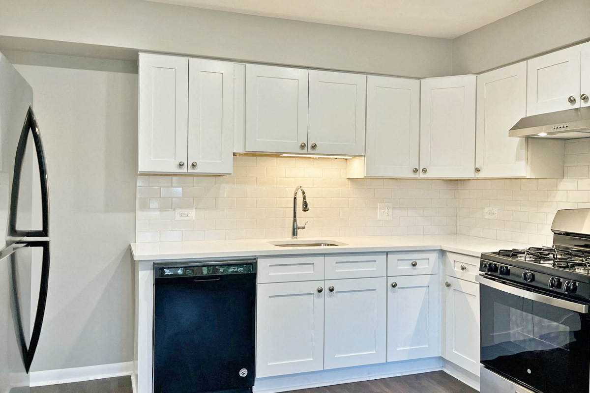 a kitchen with white cabinets and appliances and a sink