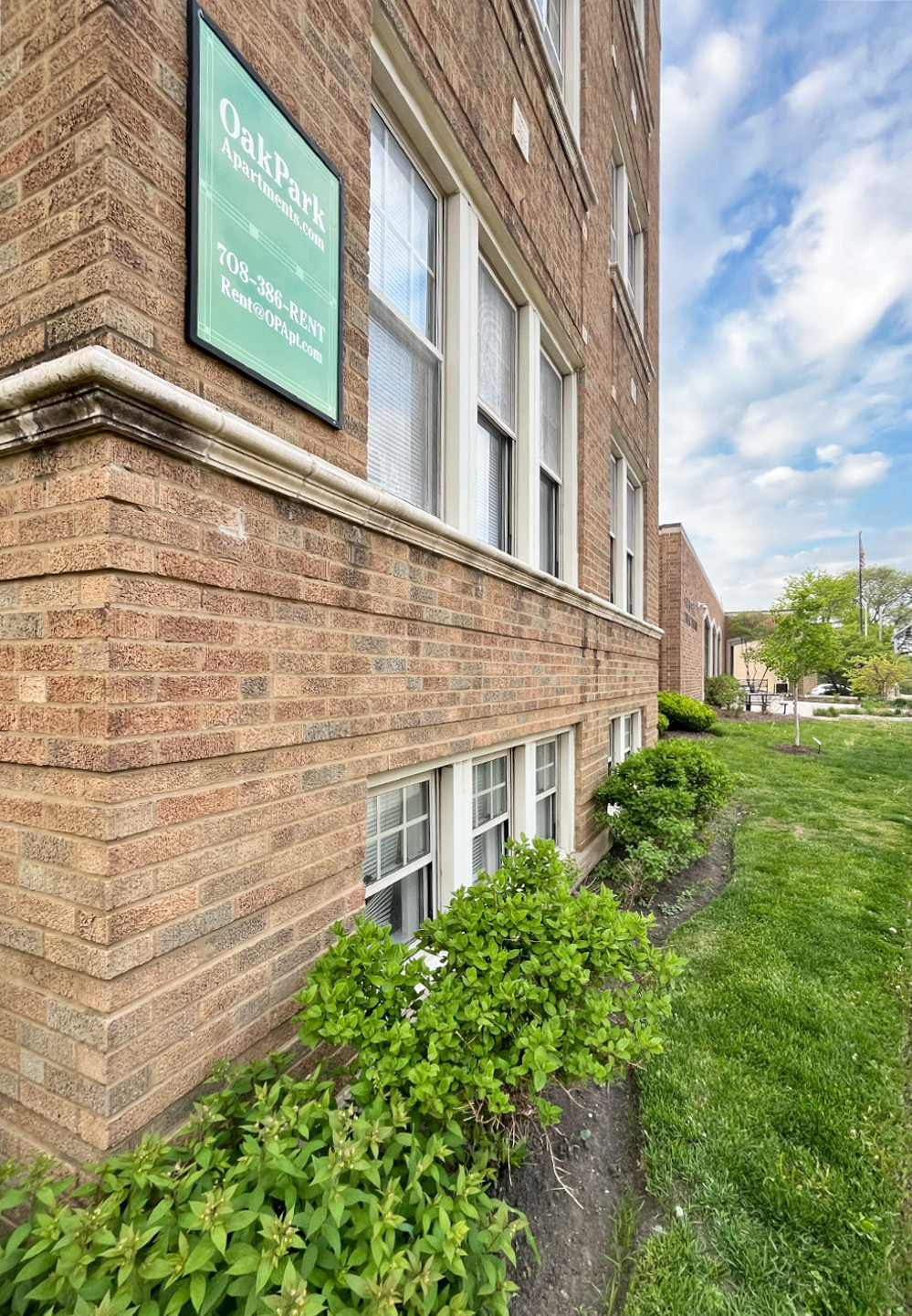 A brick building with a green sign that says Oak Park.