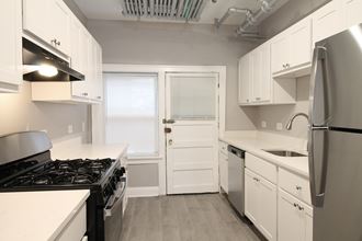 a kitchen with white cabinets and a stove and a refrigerator
