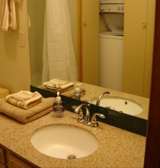 a bathroom sink with towels and a mirror