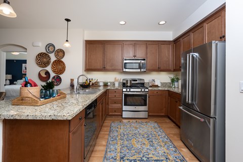 A kitchen with wooden cabinets and a granite counter top.
