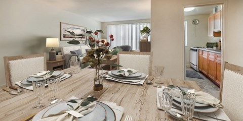 A dining room with a wooden table set for a meal.