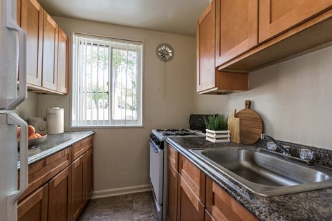 A kitchen with wooden cabinets and a stainless steel sink.