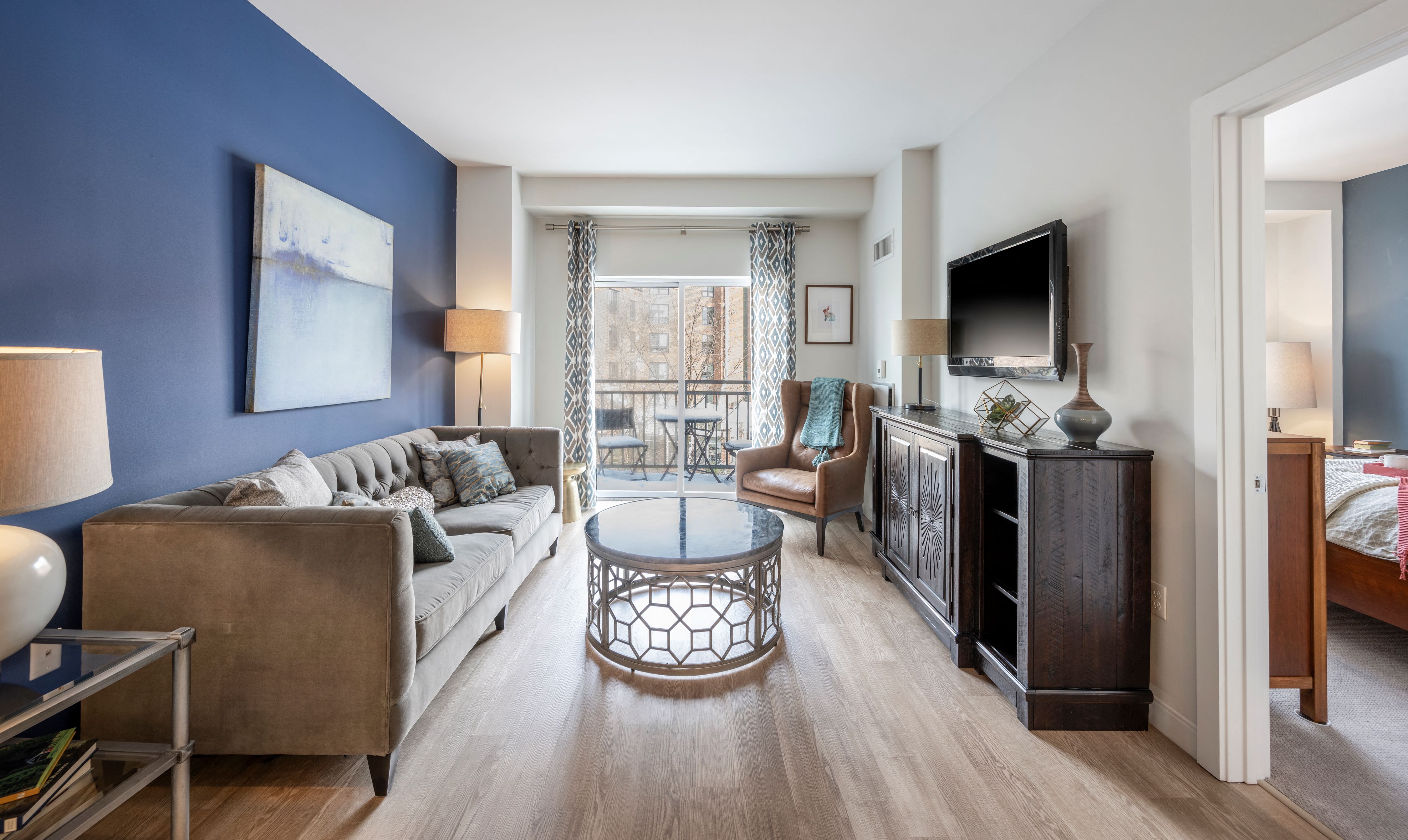 A living room with a couch, a chair, a coffee table, and a television.