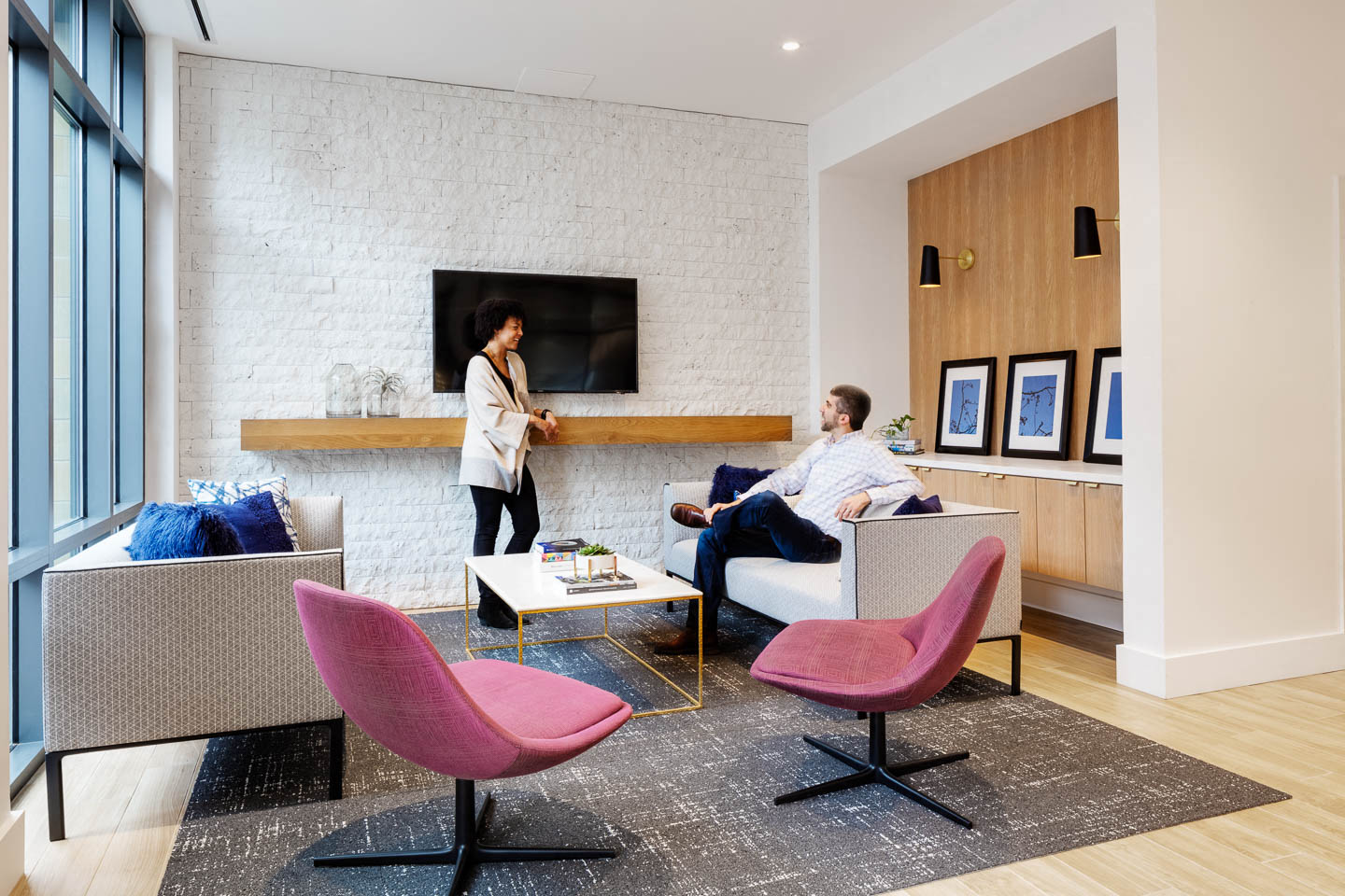a man and a woman sitting in a living room with a fireplace