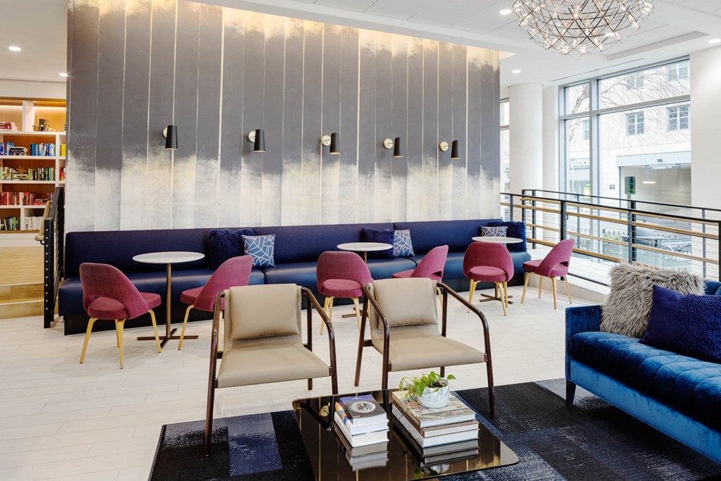 a lounge area with chairs and couches and a table with chairs