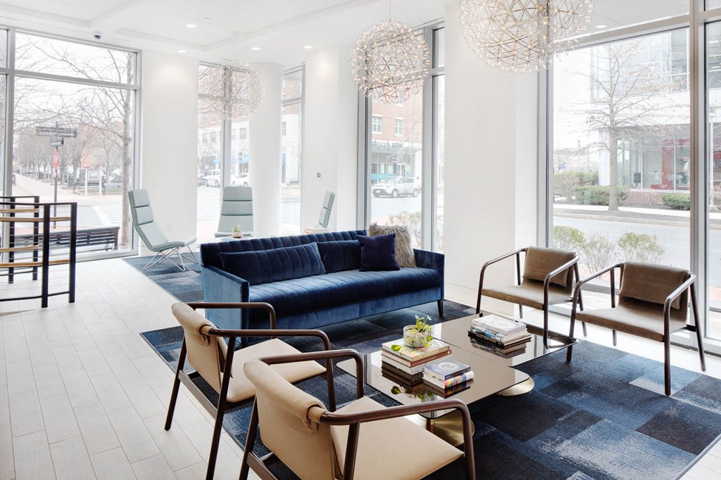 a living room with a blue couch and chairs and a table