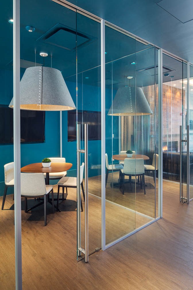 a conference room with glass walls and tables and chairs