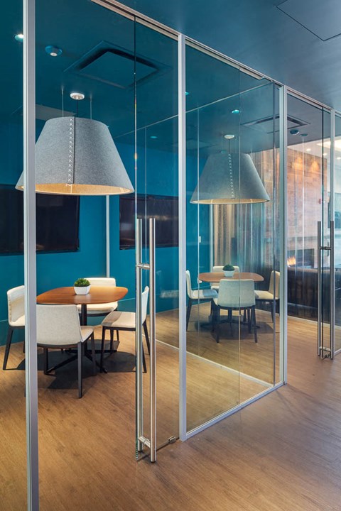 a conference room with glass walls and tables and chairs
