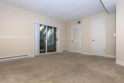 an empty living room with a door to a patio
