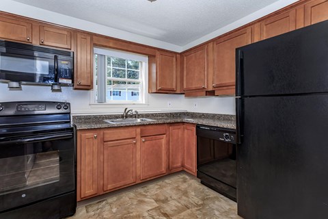 a kitchen with black appliances and wooden cabinets