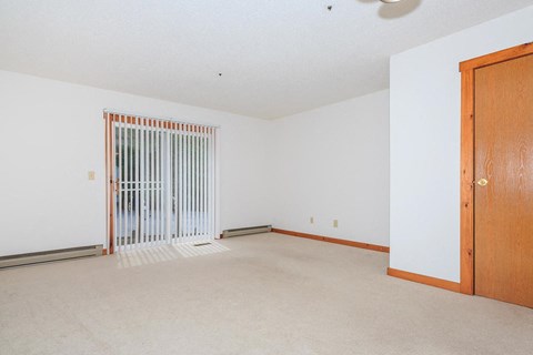 an empty living room with a door to a closet