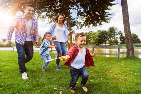 a family running in a park with a child holding a toothbrush