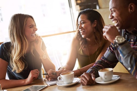 a group of people sitting at a table with coffee