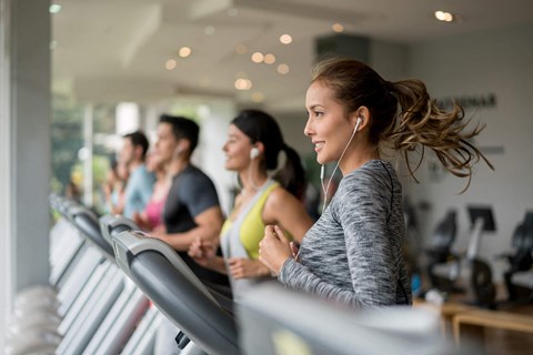 group of people exercising on a treadmill in a gym