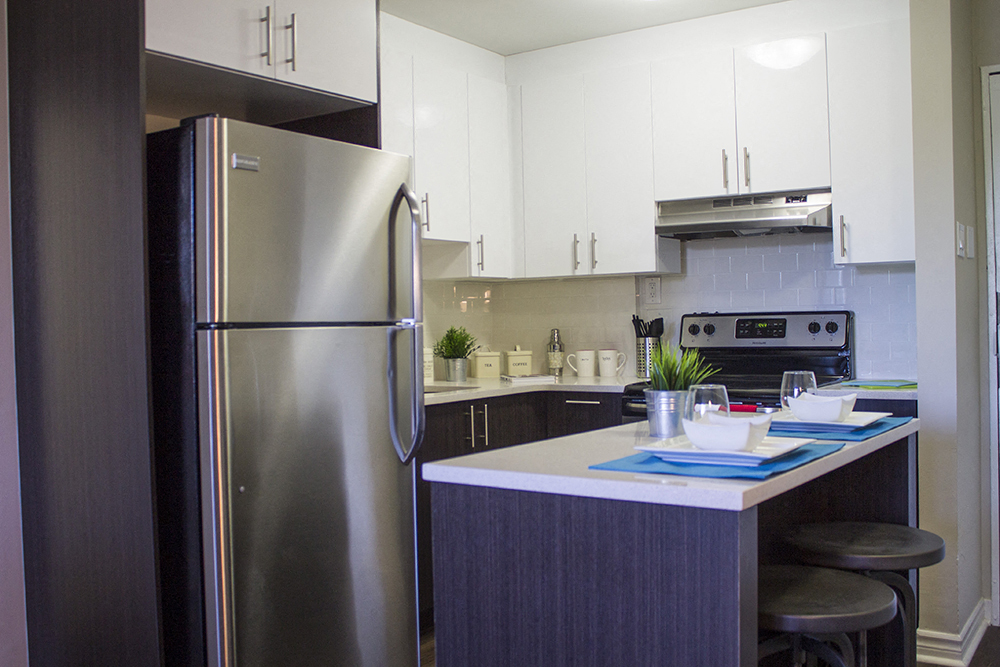 a modern kitchen with stainless steel appliances and white cabinets