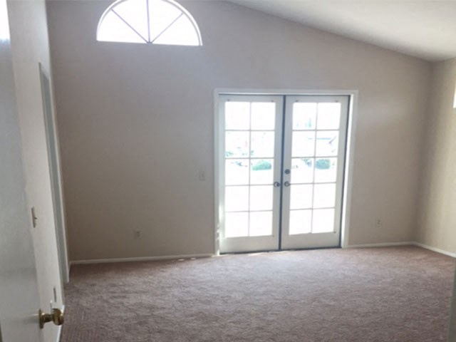 an empty living room with white walls and a glass door