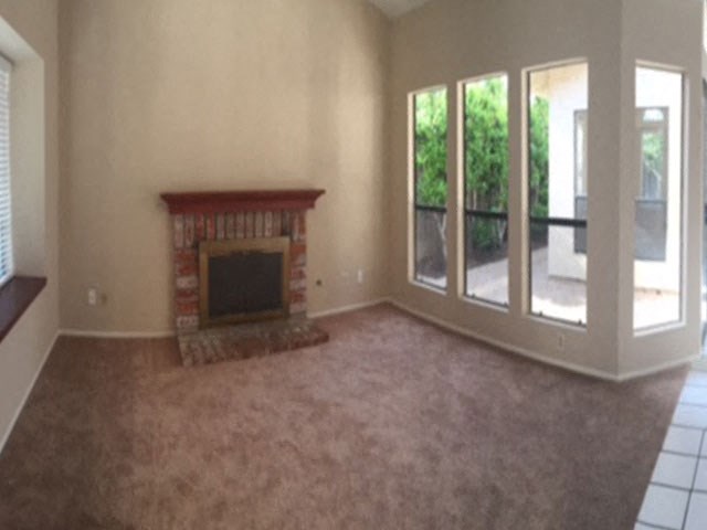 an empty living room with a fireplace and a balcony