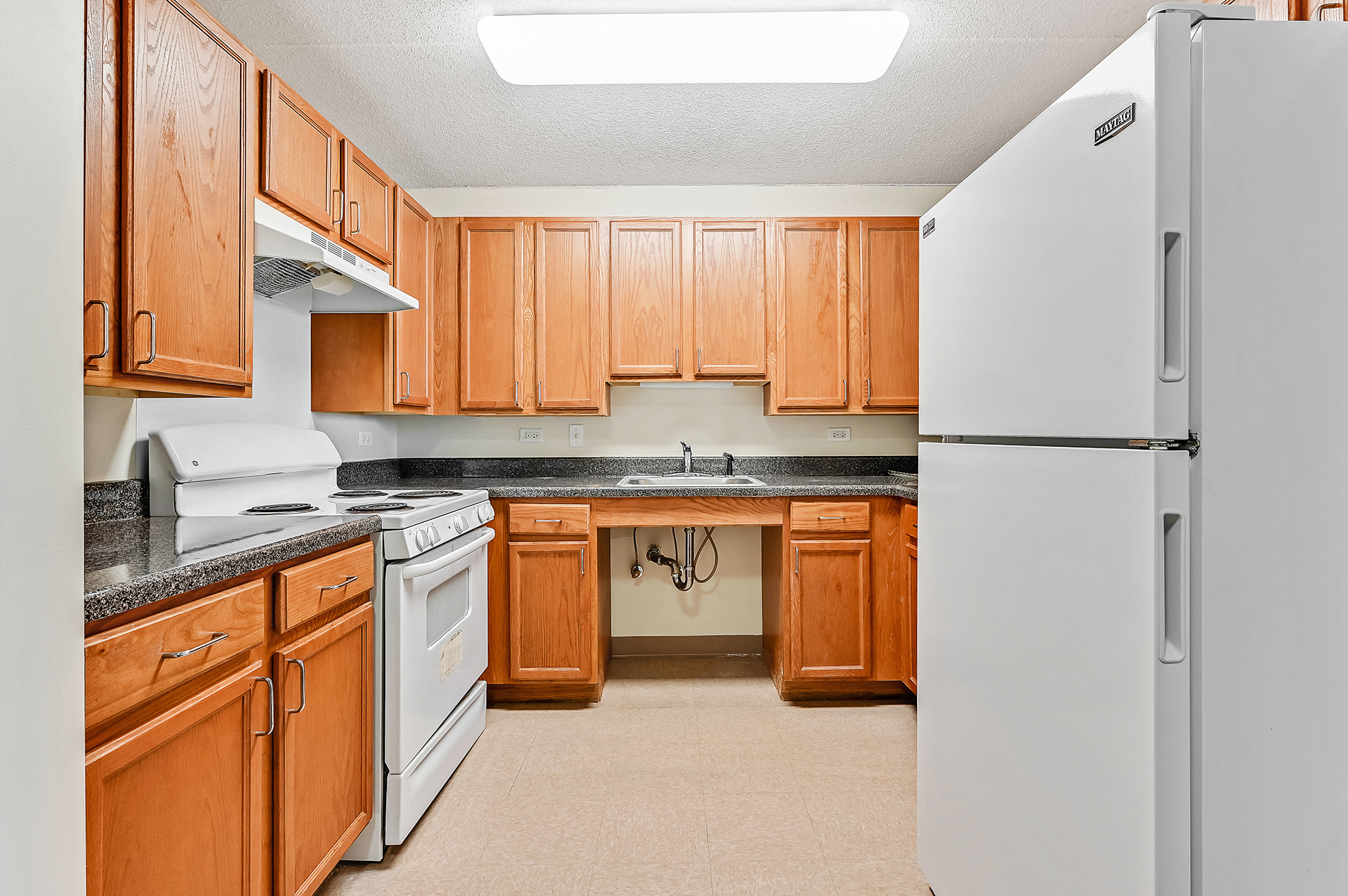 a kitchen with white appliances and wooden cabinets